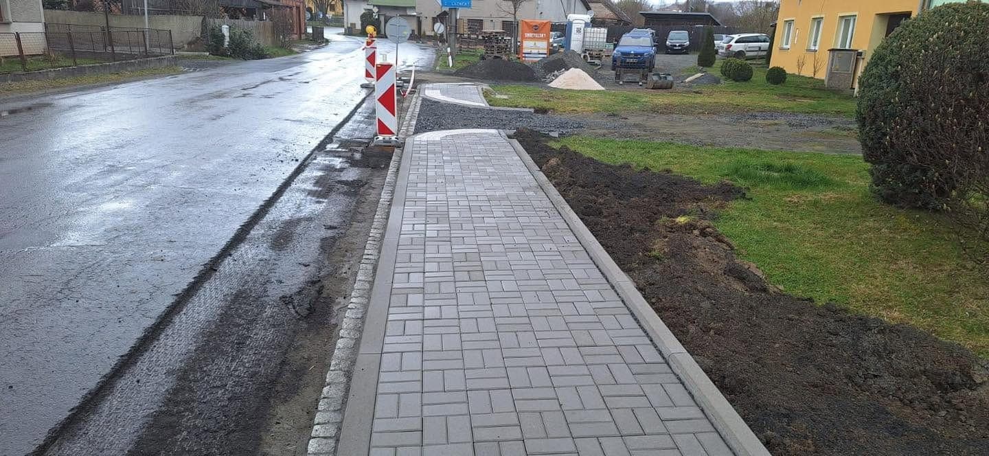 Chodník v obci Výkleky — Nový chodník v obci včetně obrub a napojení na stávající zpevněné plochy.